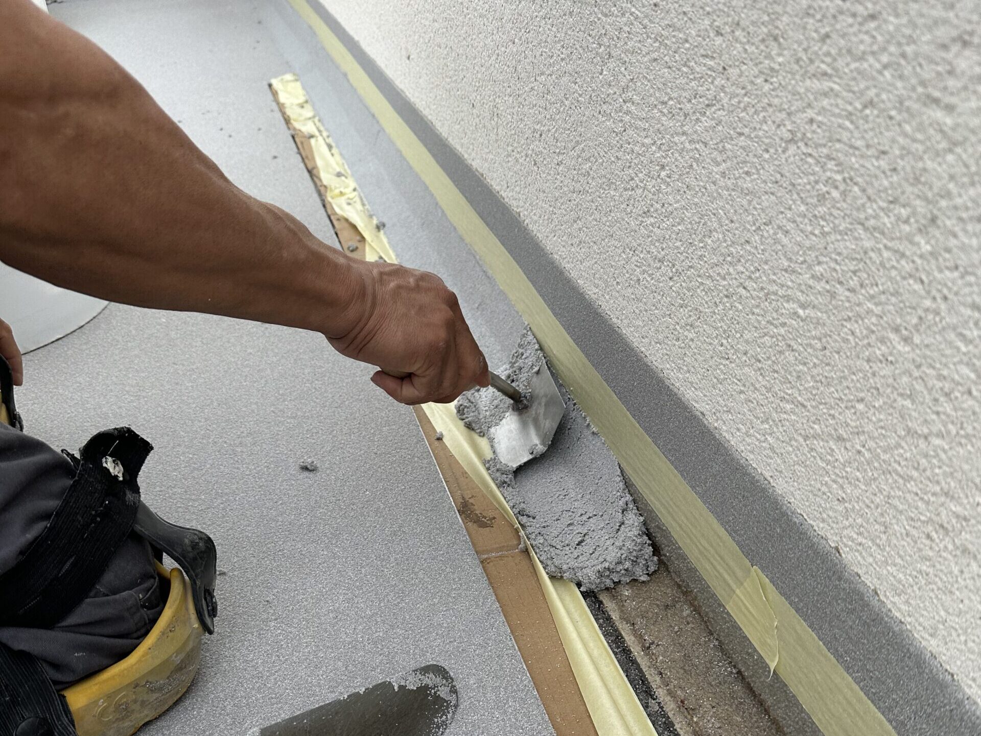 Operario de Erde Pavimentos aplicando zócalo sanitario