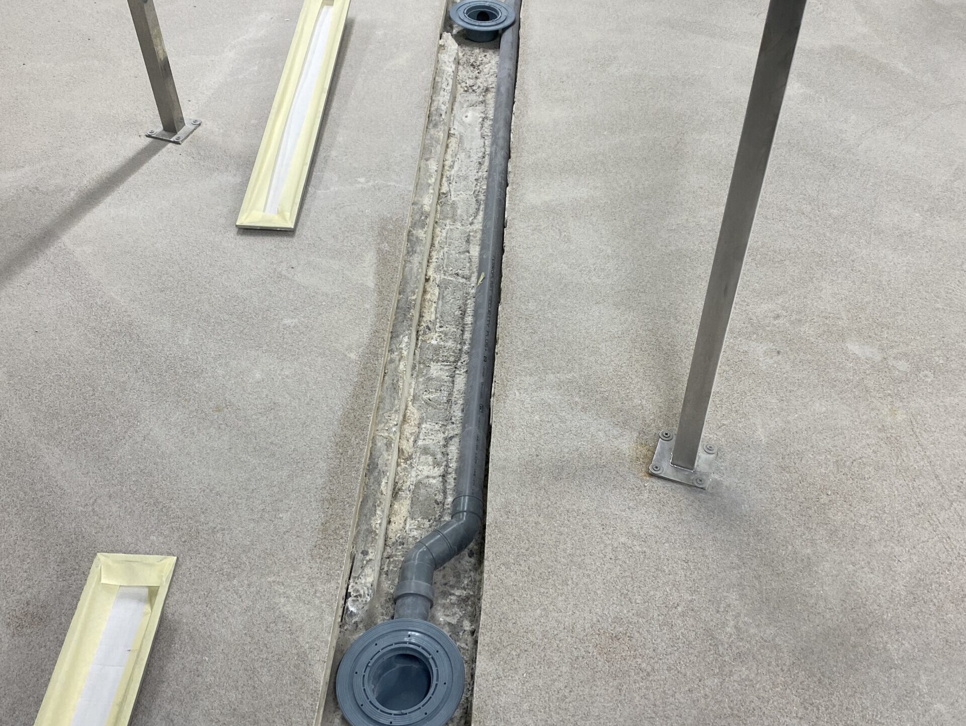 Pavimento con tubos colocados para la futura instalación de canales de drenaje