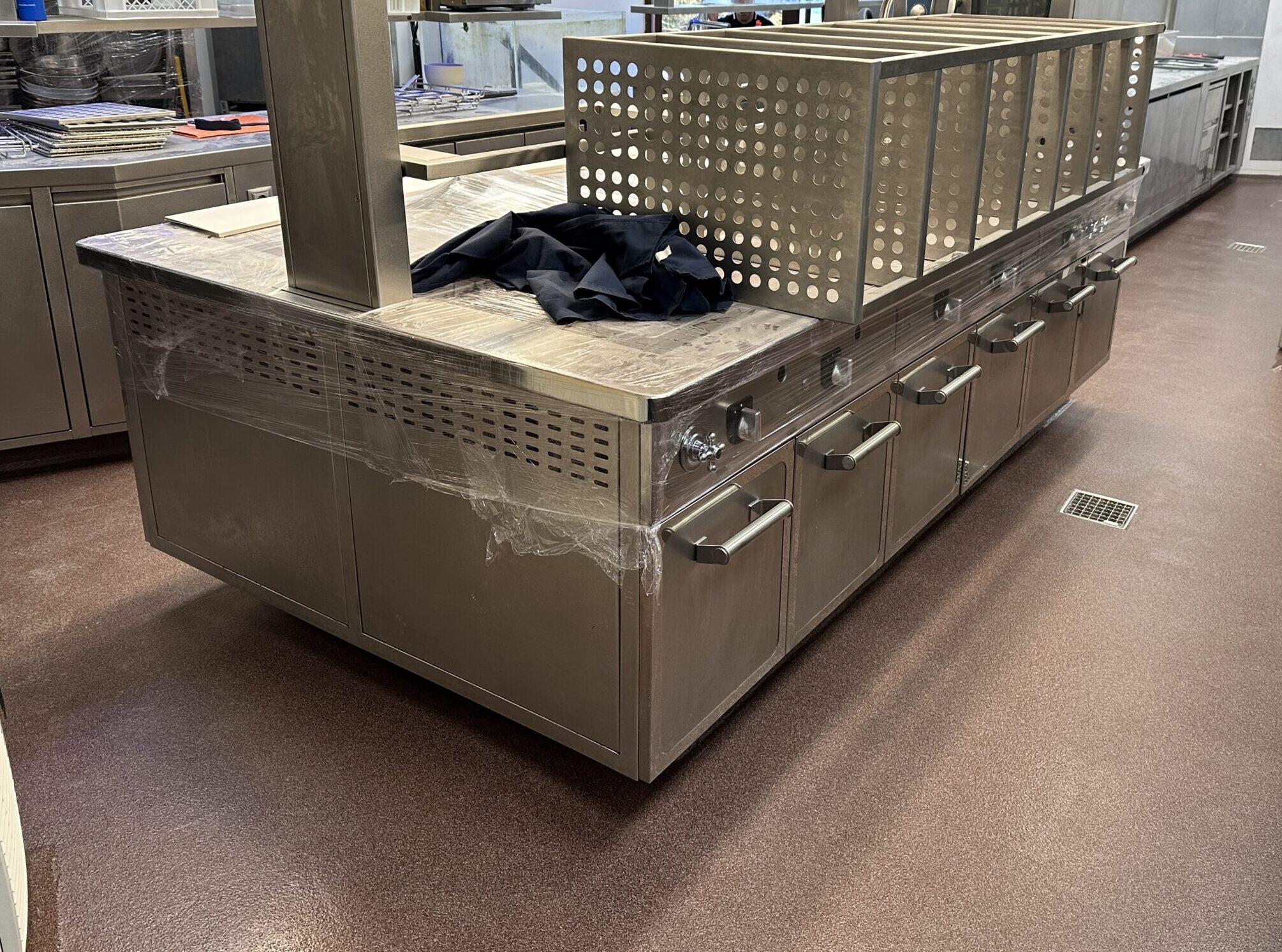 Pavimento continuo de resina de metacrilato en color marrón rojizo aplicado en una cocina.