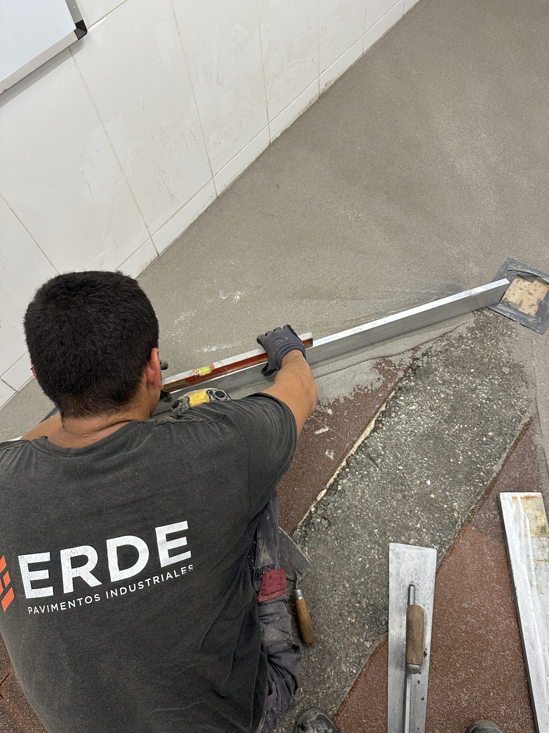 Operario de Erde Pavimentos creando pendientes en pavimento para correcto drenaje.