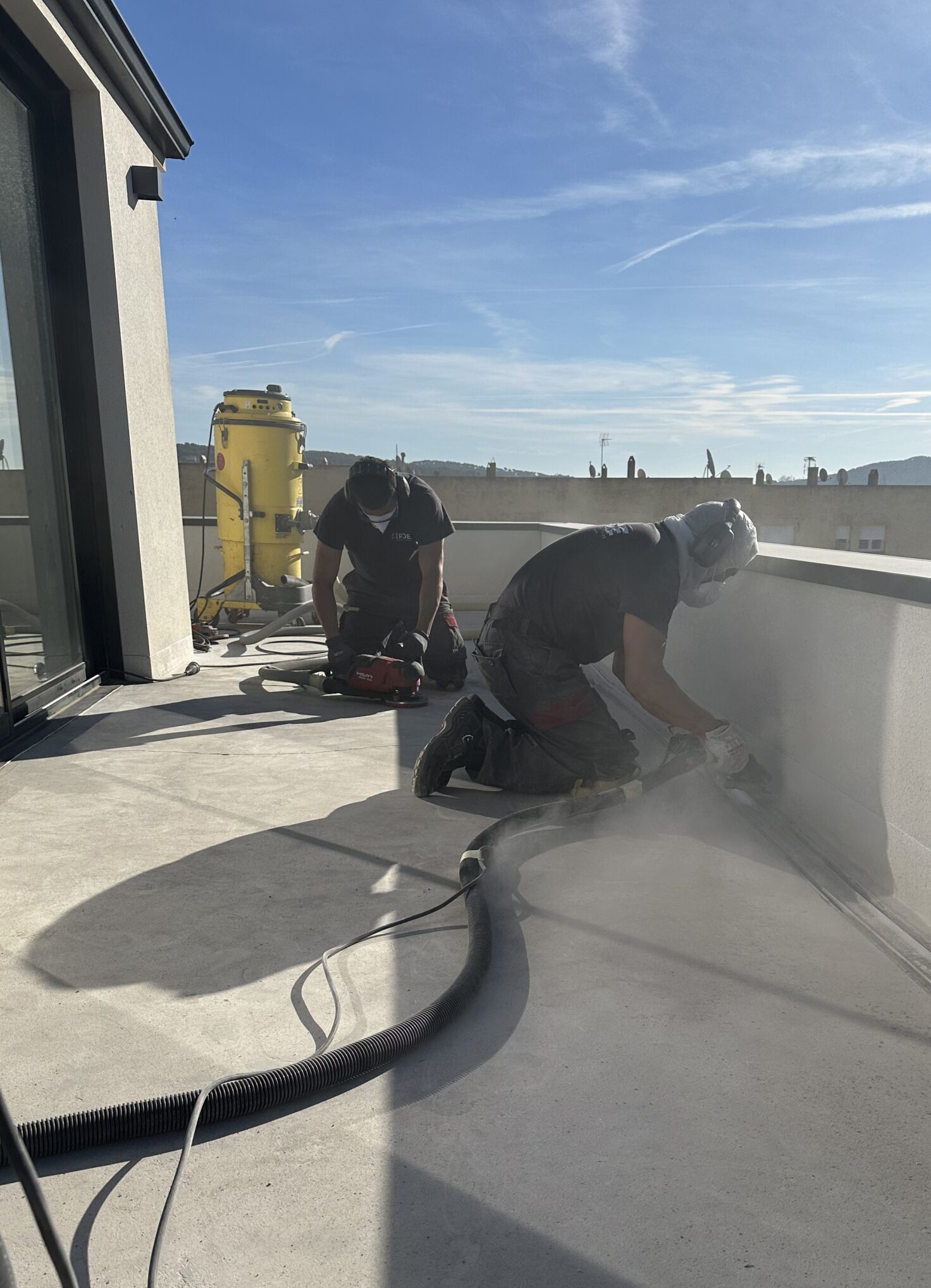 Trabajadores de Erde Pavimentos puliendo el suelo de una terraza