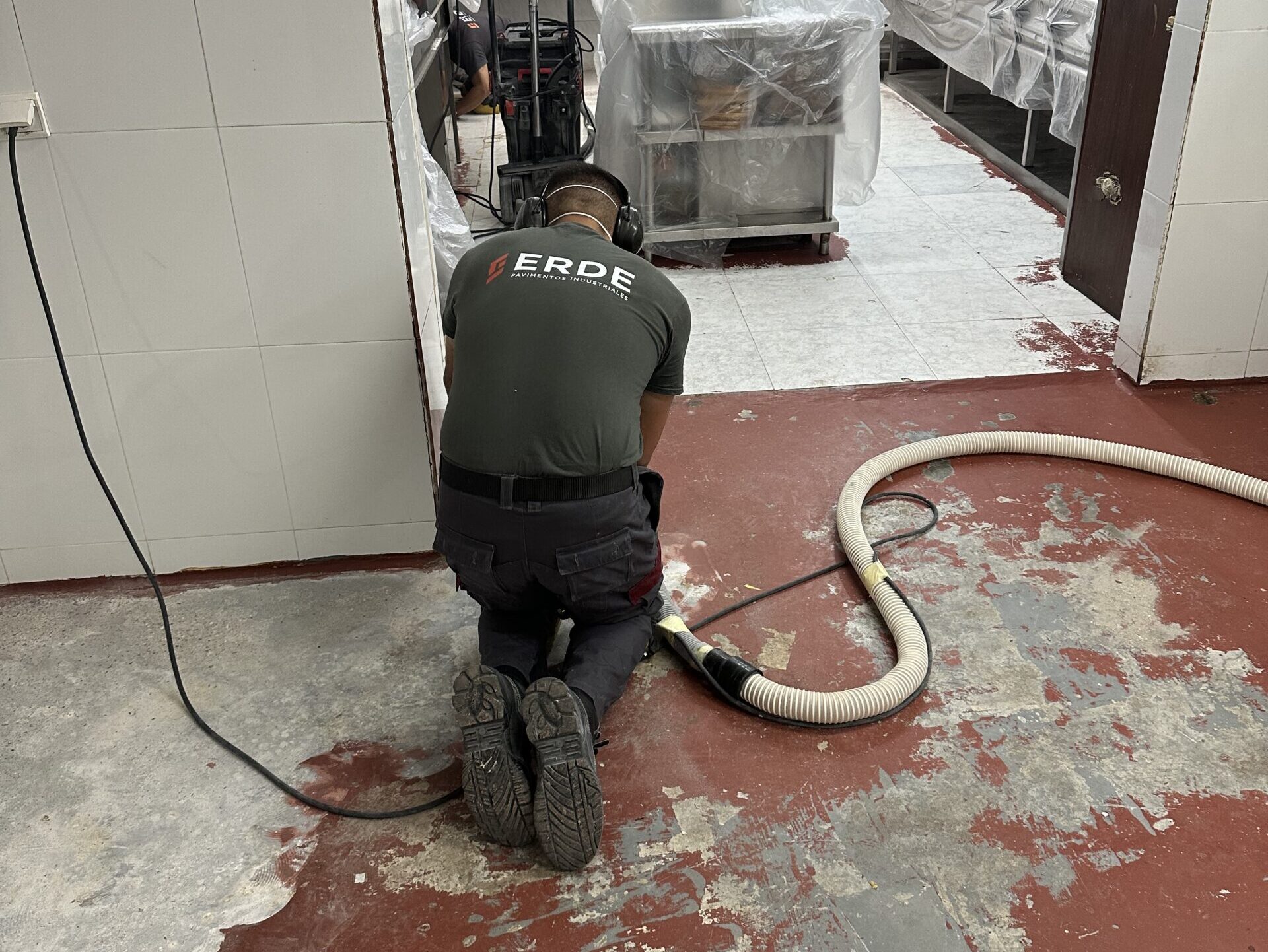 Trabajador de Erde Pavimentos puliendo pavimento para eliminar el color antiguo