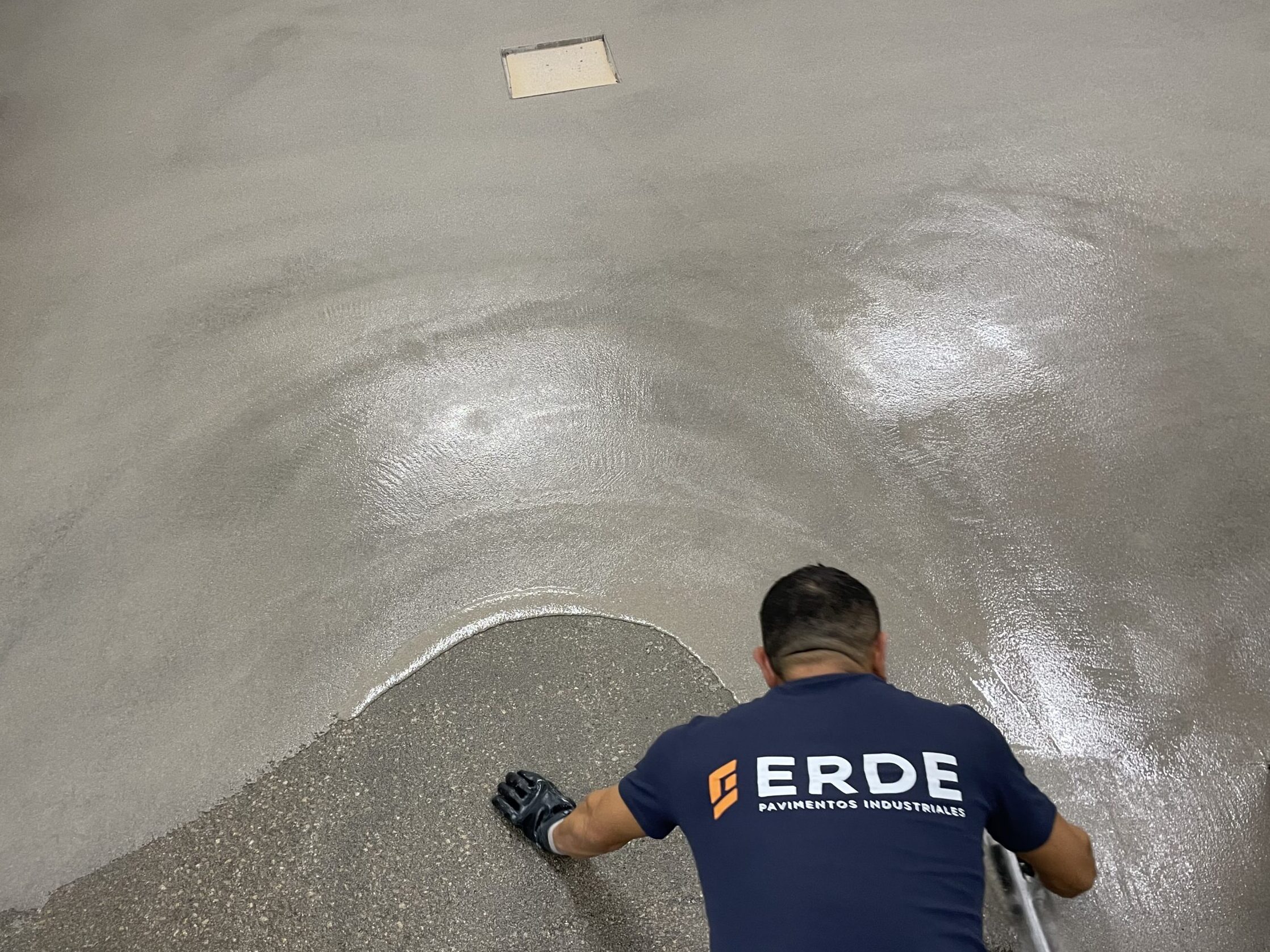 Operario aplicando una de las capas sobre el pavimento