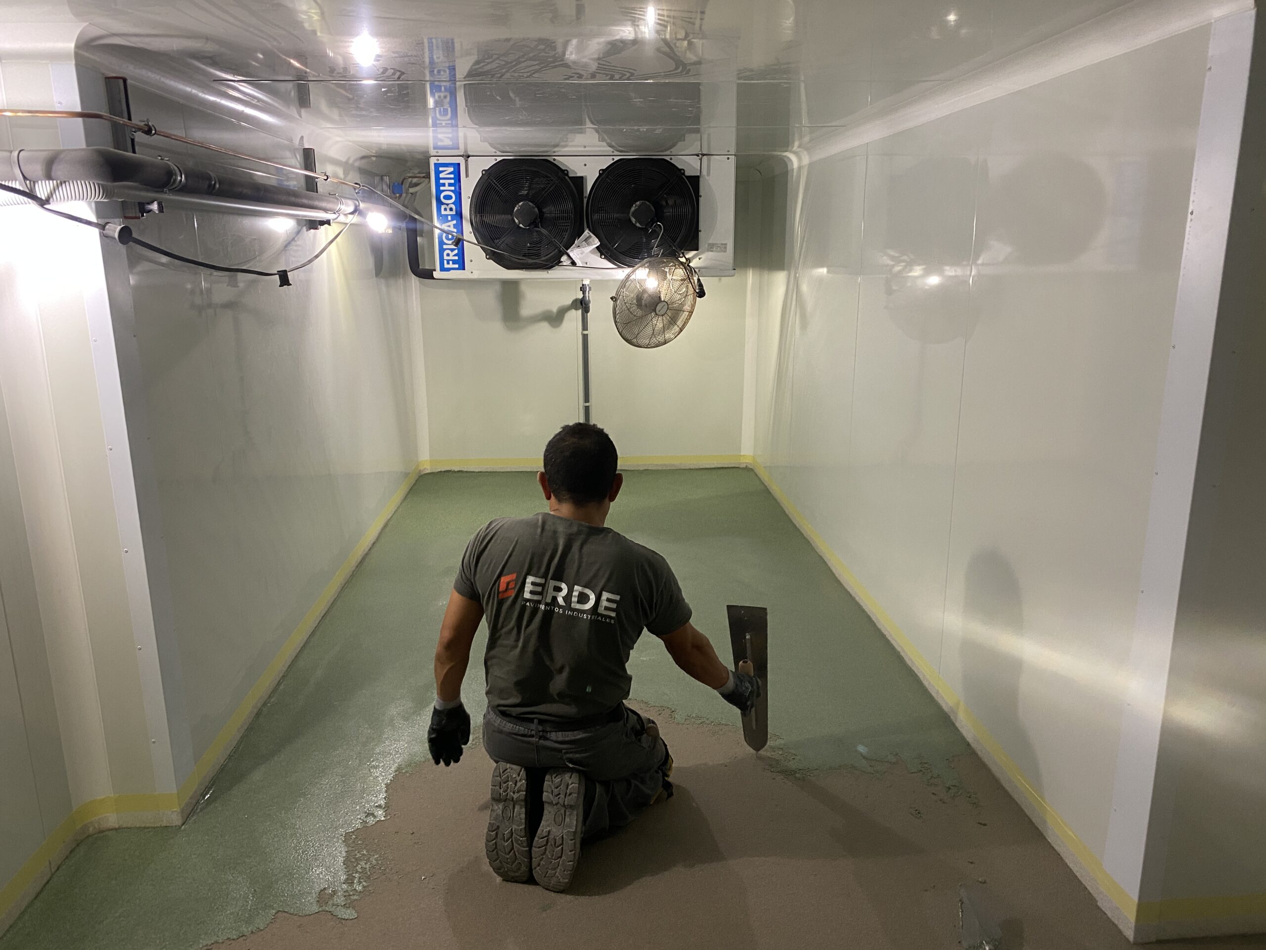 Operario aplicando una de las capas de pavimento con resina de metacrilato sobre la superficie preparada y ya con capa de imprimación aplicada